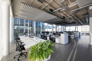 Modern en licht open kantoorinterieur aan de Fred. Roeskestraat met werkplekken, grote ramen en zichtbare plafondinstallaties.